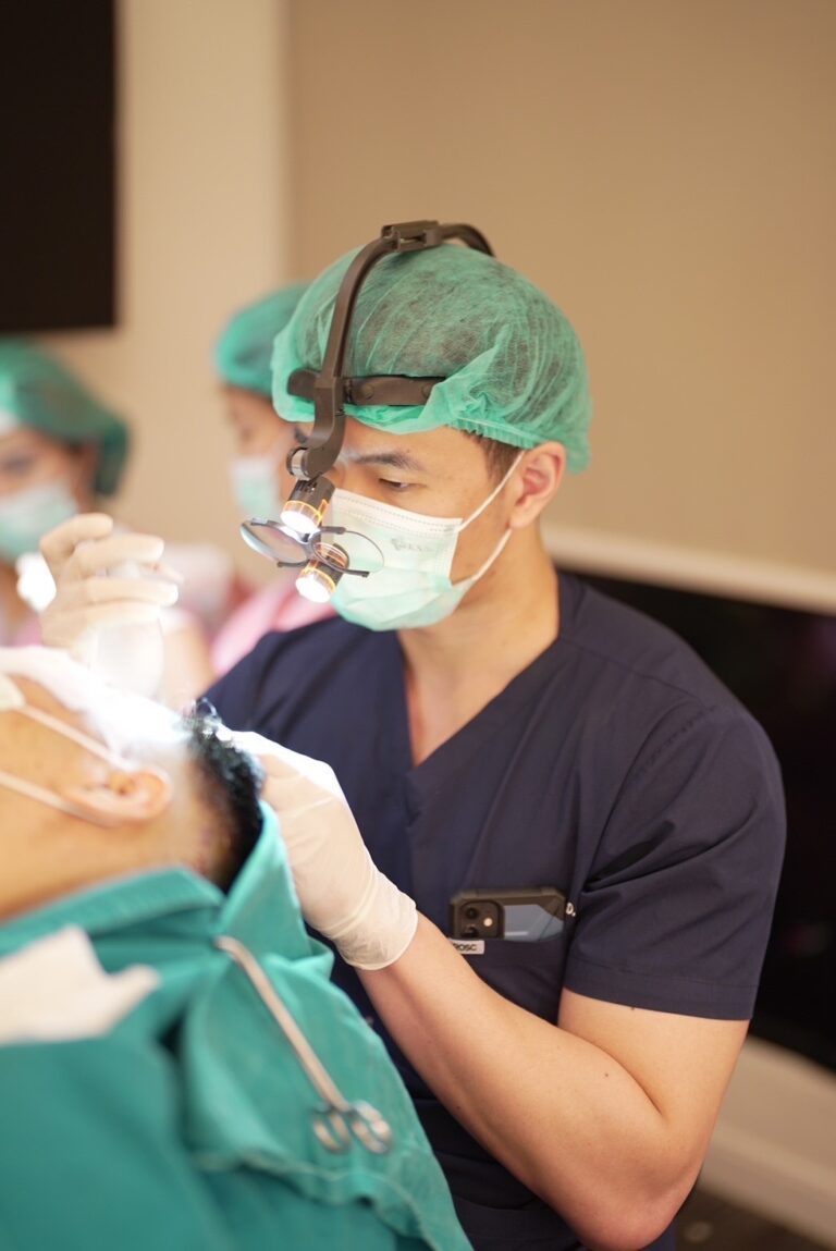 แพทย์ Noble Hair Clinic กำลังทำหัตถการปลูกผมด้วยแว่นขยายผ่าตัด